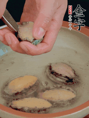 鮑魚加鹽、清水浸泡，用勺子挖出鮑魚肉。