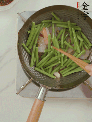 下掰好的缸豆段翻炒，略燜煮。