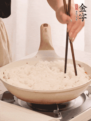 把瀝干水分的米飯均勻鋪在上面，筷子戳幾個洞，以便透氣，轉小火蓋上蓋子燜至水分收干，大概10分鐘。