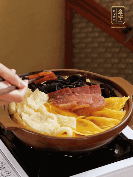 砂鍋底部鋪上娃娃菜，依次擺上肉皮、蛋餃、黑木耳、火腿